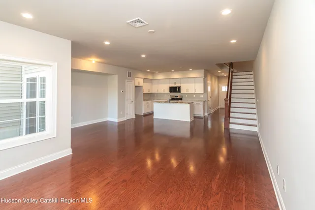 a view of a big room with wooden floor and windows