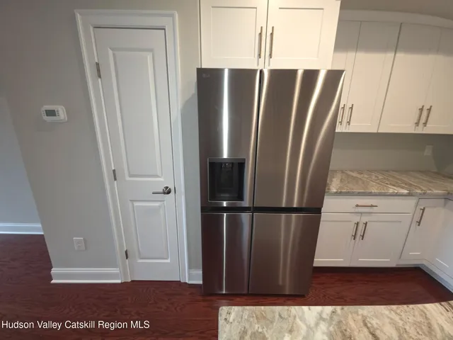 a view of kitchen with refrigerator and wooden floor