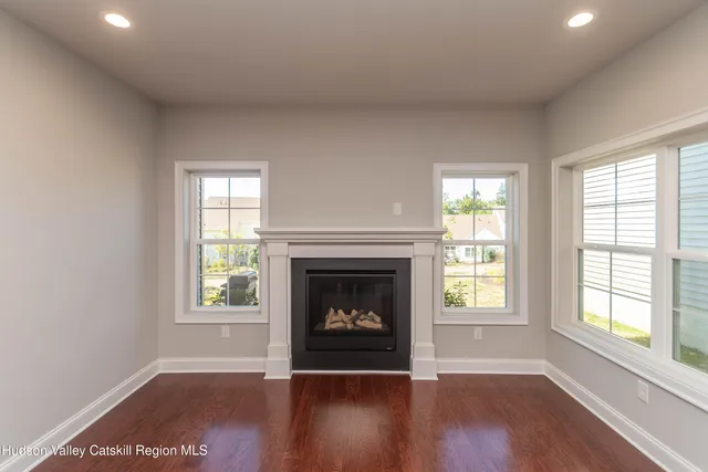 an empty room with windows and fireplace