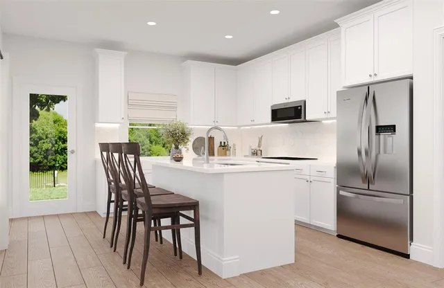 a kitchen with kitchen island a appliances dining table and chairs