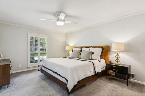 a bed sitting in a bedroom next to a window