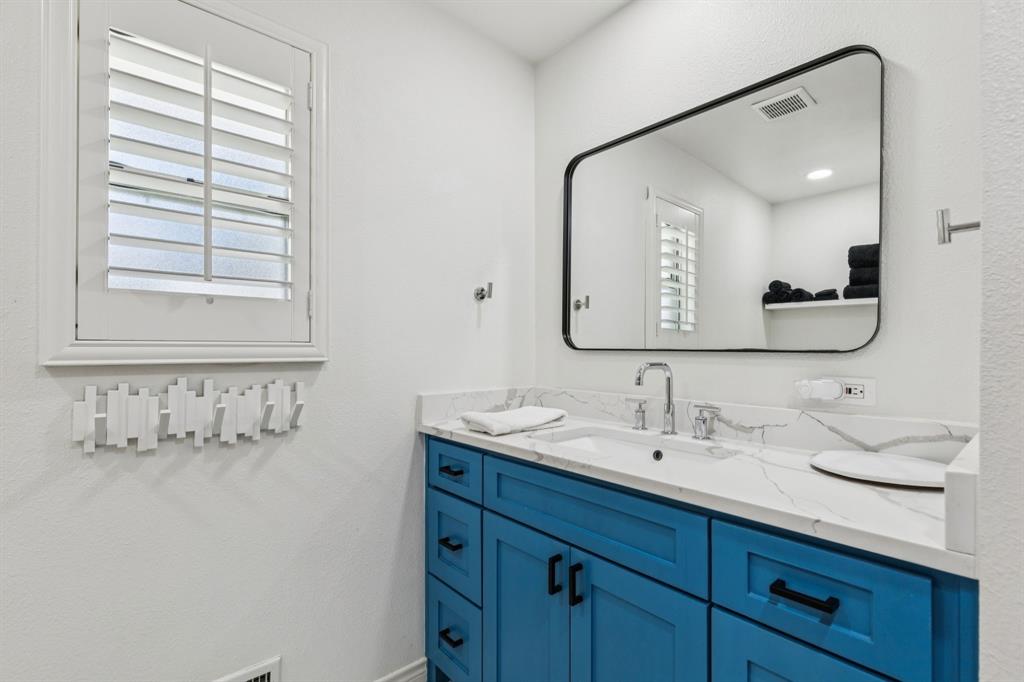 6222 East University Boulevard Dallas, TX 75214 - Photo 16 of 25 a bathroom with a double vanity sink and a mirror