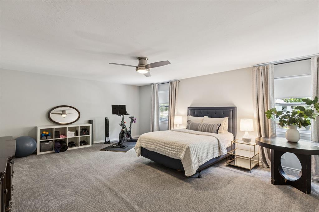 6222 East University Boulevard Dallas, TX 75214 - Photo 18 of 25 a bedroom with a bed and a chandelier