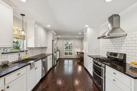 a kitchen with stainless steel appliances a sink stove and cabinets