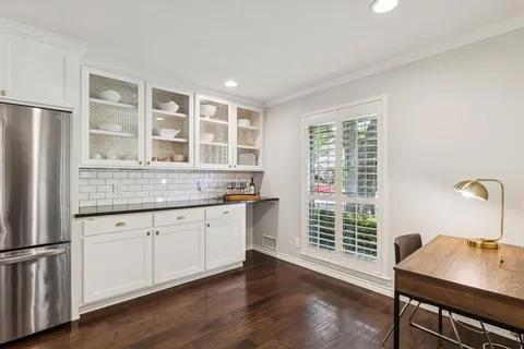a kitchen with granite countertop white cabinets and wooden floor