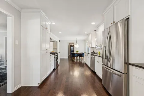 a kitchen with stainless steel appliances a refrigerator and a stove top oven
