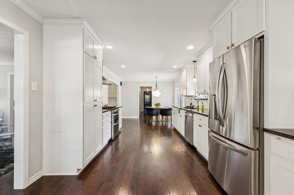 6222 East University Boulevard Dallas, TX 75214 - Photo 9 of 25 a kitchen with stainless steel appliances a refrigerator and a stove top oven