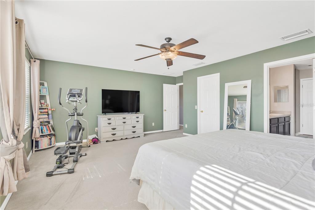 18345 Fish Loop Land O Lakes, FL 34638 - Photo 17 of 36 a bedroom with a white bed and a flat screen tv