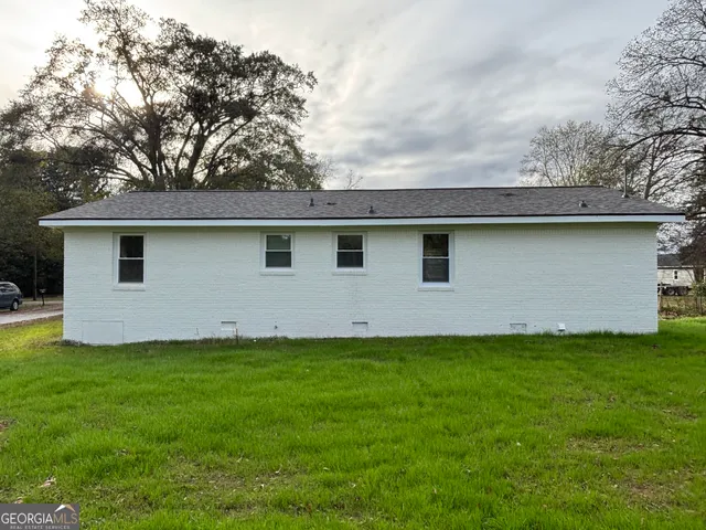 a view of a grassy field with trees