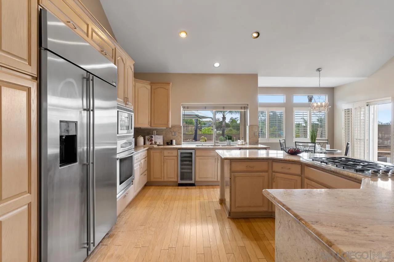 12245 Malabar Drive Poway, CA 92064 - Photo 18 of 43 a kitchen with stainless steel appliances granite countertop sink and wooden cabinets