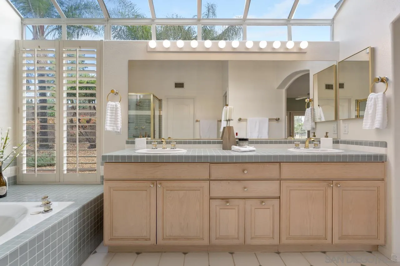 12245 Malabar Drive Poway, CA 92064 - Photo 30 of 43 a bathroom with a granite countertop sink and a large mirror