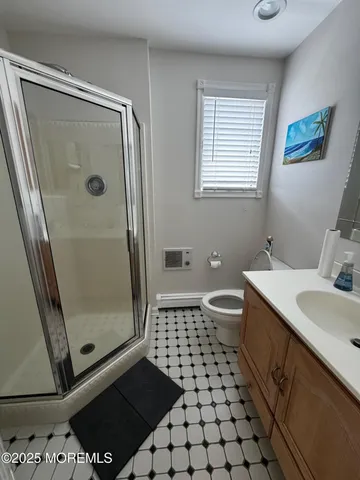 a bathroom with a sink a toilet a mirror and shower