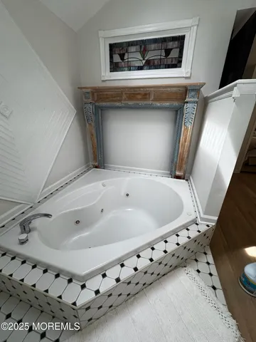 a bathroom with a tub sink and mirror