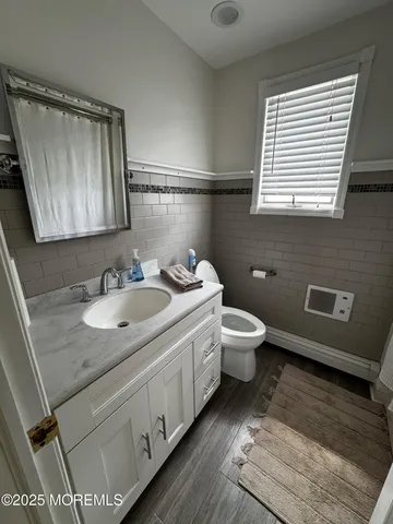a bathroom with a granite countertop sink toilet and mirror