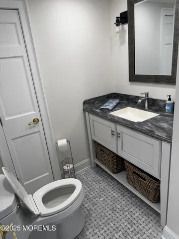 a bathroom with a granite countertop toilet sink and mirror