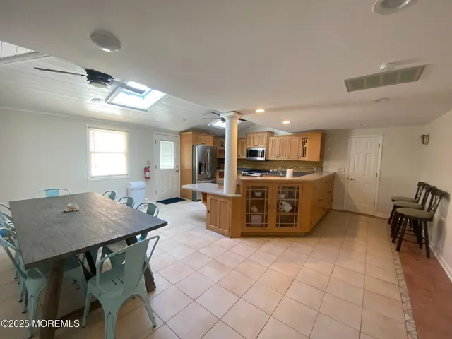 a kitchen with kitchen island a table and chairs in it