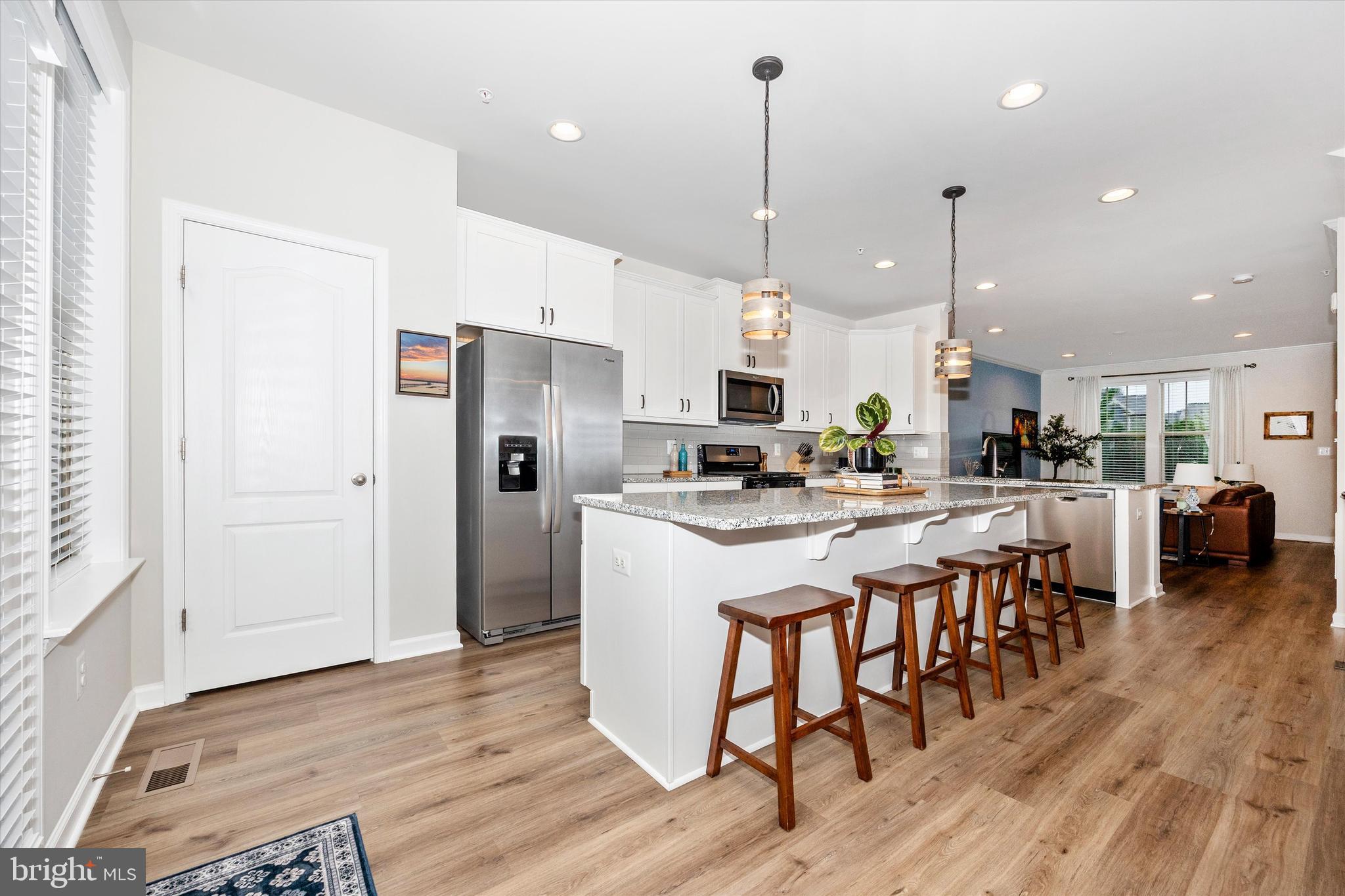 1817 Bird Run Frederick, MD 21702 - Photo 11 of 31 a kitchen with stainless steel appliances kitchen island granite countertop a refrigerator a stove a sink and a dining table with wooden floor