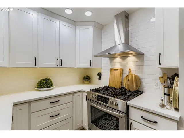 a kitchen with a stove and white cabinets