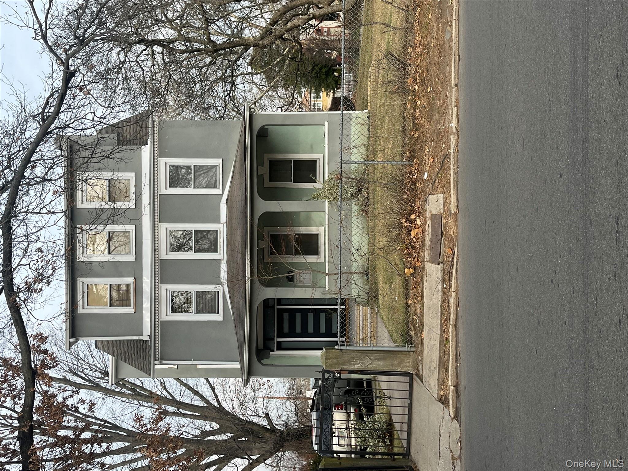 View of front of home with a gate, stucco siding, covered porch, and a fenced front yard