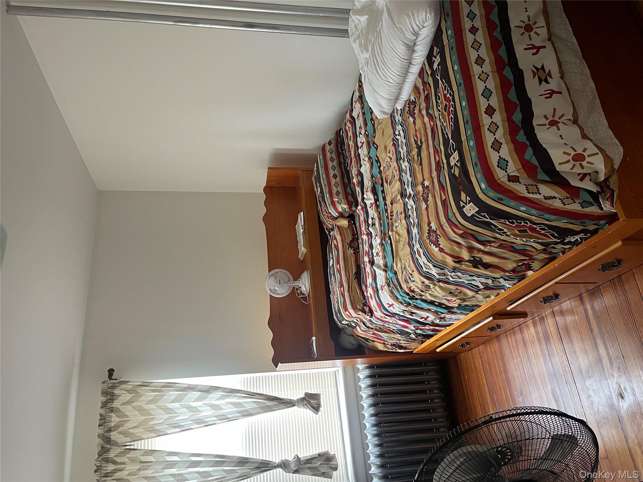 149 West Kingsbridge Road Mount Vernon, NY 10550 - Photo 11 of 25 Bedroom with radiator heating unit and hardwood / wood-style flooring