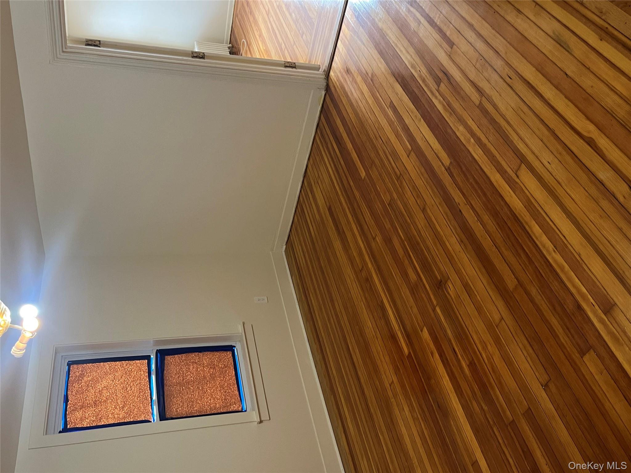 149 West Kingsbridge Road Mount Vernon, NY 10550 - Photo 14 of 25 Empty room with dark wood-style floors and radiator