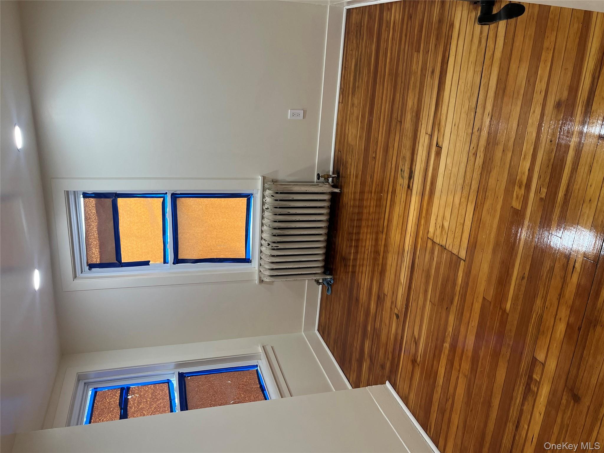 149 West Kingsbridge Road Mount Vernon, NY 10550 - Photo 15 of 25 Unfurnished room with radiator, dark wood-type flooring, and recessed lighting