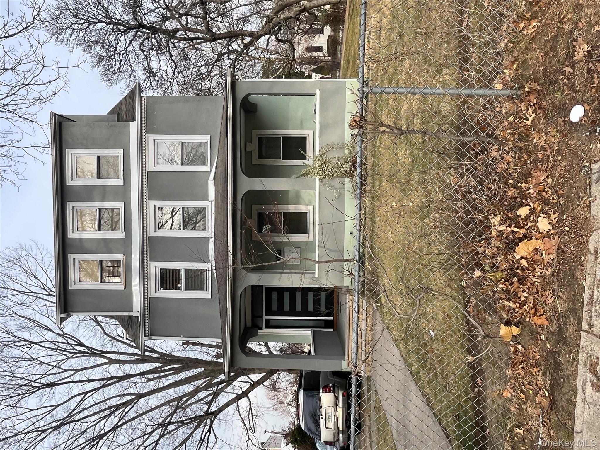 149 West Kingsbridge Road Mount Vernon, NY 10550 - Photo 20 of 25 American foursquare style home with covered porch, a fenced front yard, and stucco siding