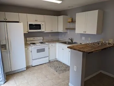 a kitchen with white cabinets and white appliances