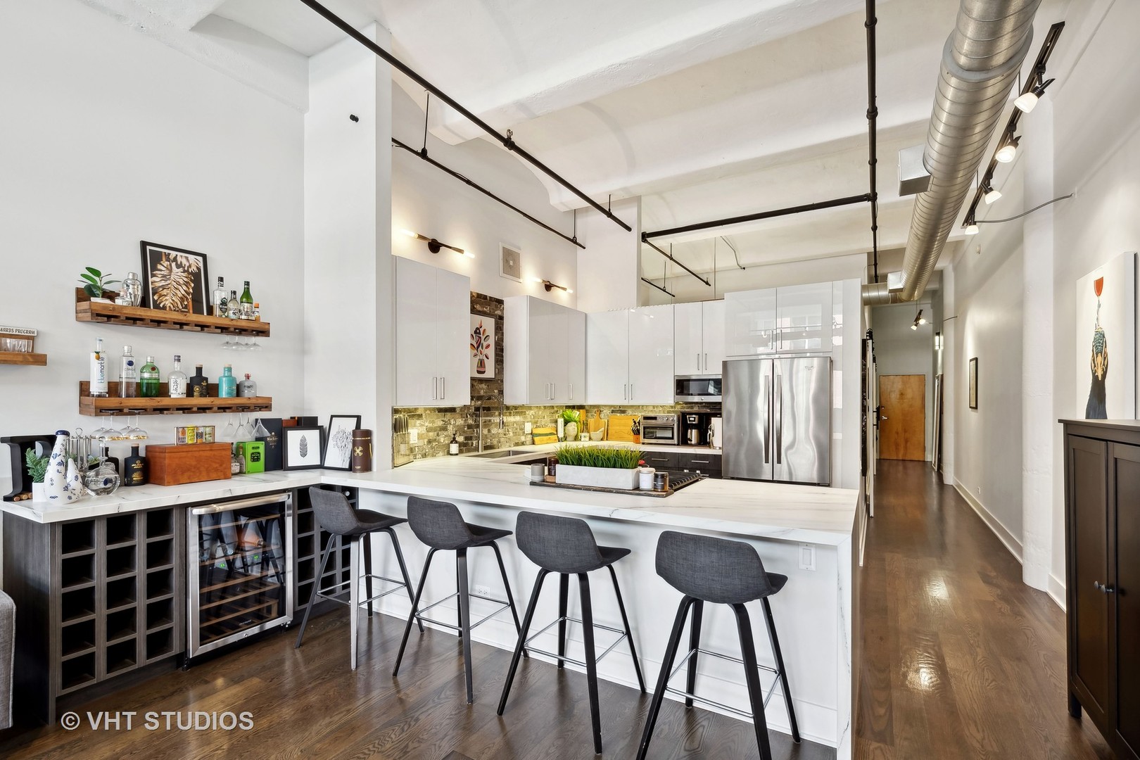 1000 West Washington Boulevard, Unit 319 Chicago, IL 60607 - Photo 5 of 15 a kitchen with stainless steel appliances kitchen island granite countertop a table chairs and a refrigerator