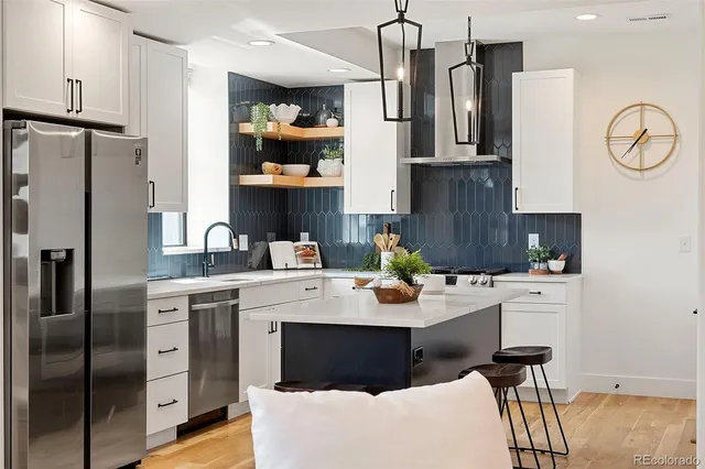 a kitchen with stainless steel appliances a refrigerator sink and cabinets