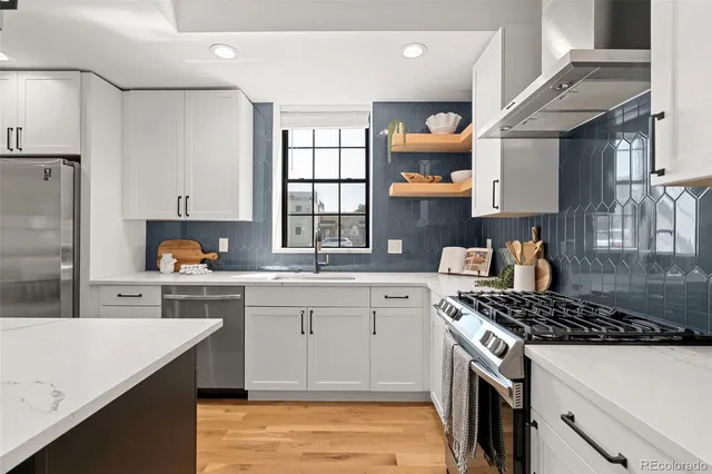 a kitchen with stainless steel appliances granite countertop a sink stove and cabinets