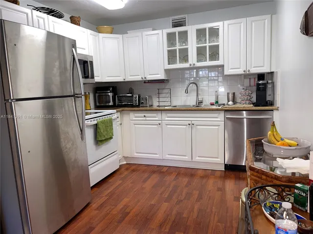 a kitchen with stainless steel appliances granite countertop a refrigerator sink and stove