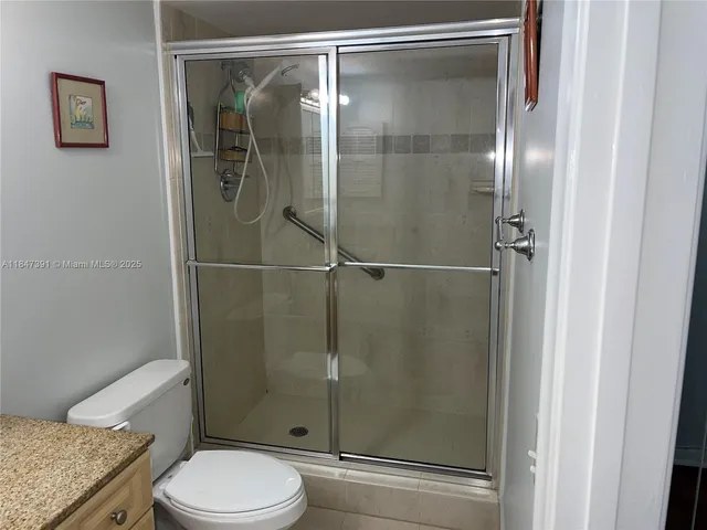 a bathroom with a granite countertop toilet sink and shower