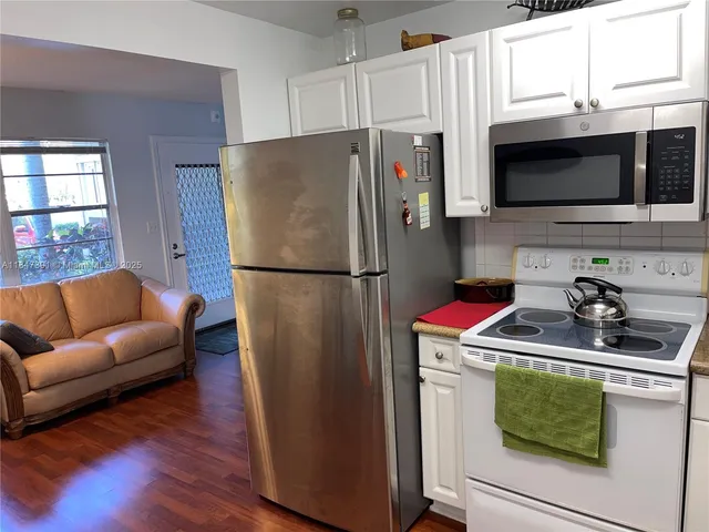 a kitchen with stainless steel appliances granite countertop a refrigerator stove and microwave