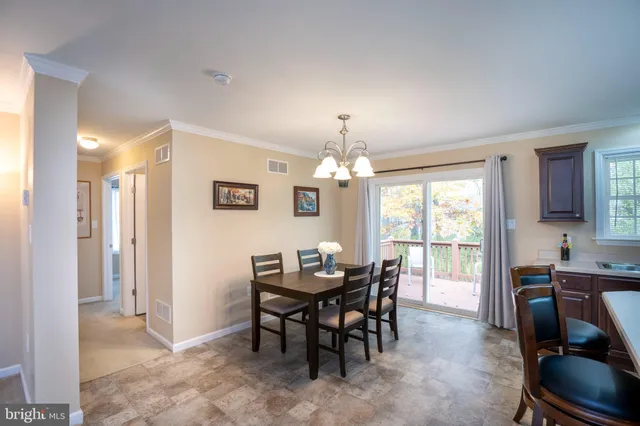 a view of a dining room with furniture and a chandelier