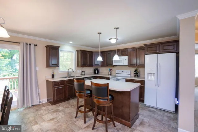 a kitchen with a dining table chairs and refrigerator
