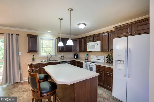 a kitchen with a table a refrigerator a sink and chairs