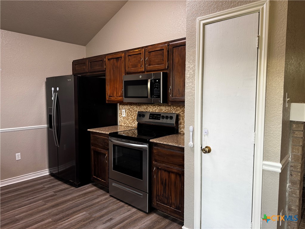 397 County Road 3367 Kempner, TX 76539 - Photo 15 of 47 a kitchen with granite countertop a refrigerator and a stove