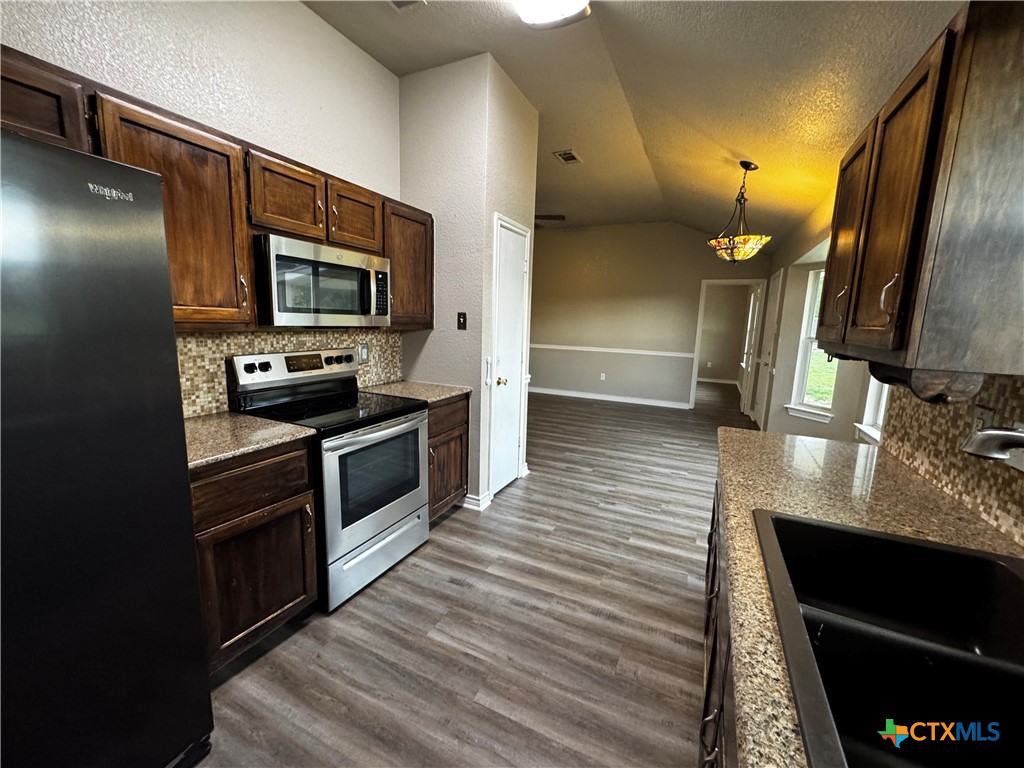397 County Road 3367 Kempner, TX 76539 - Photo 16 of 47 a kitchen with stainless steel appliances wooden cabinets a stove and a sink