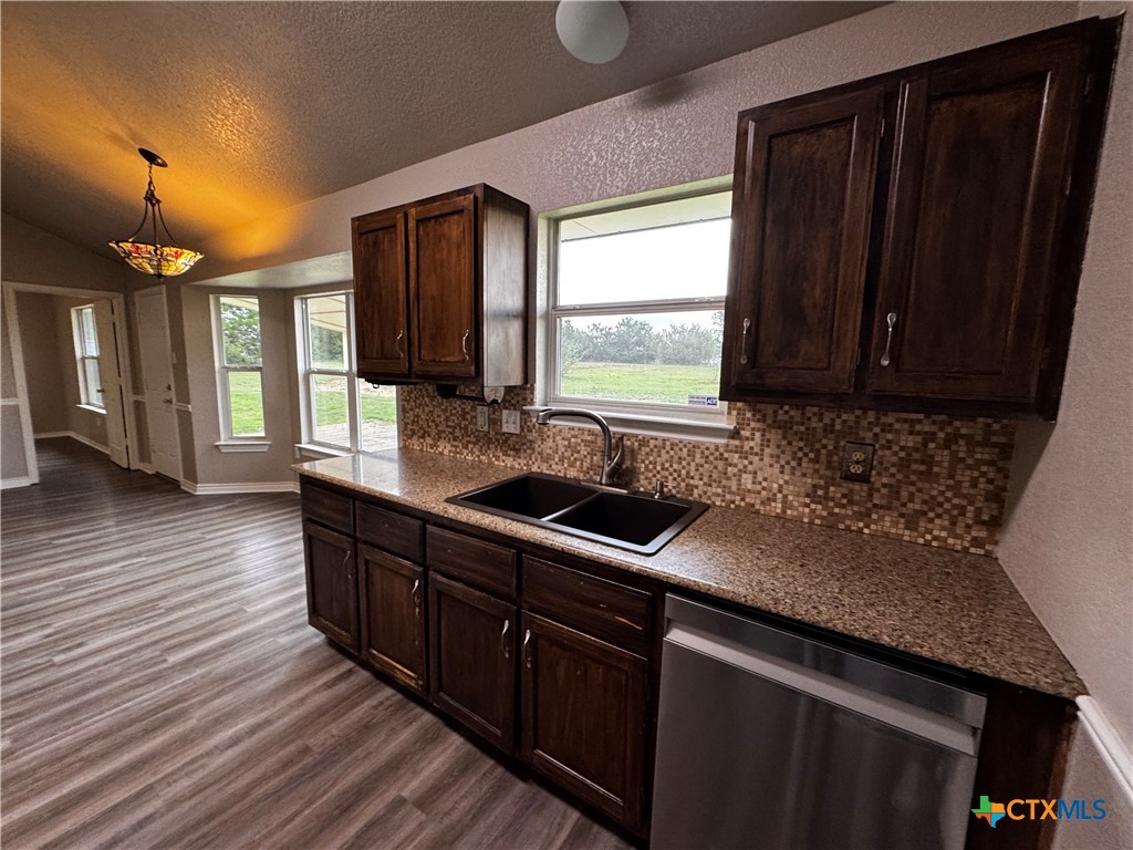 397 County Road 3367 Kempner, TX 76539 - Photo 17 of 47 a kitchen with stainless steel appliances granite countertop wooden cabinets a refrigerator a sink and a large window