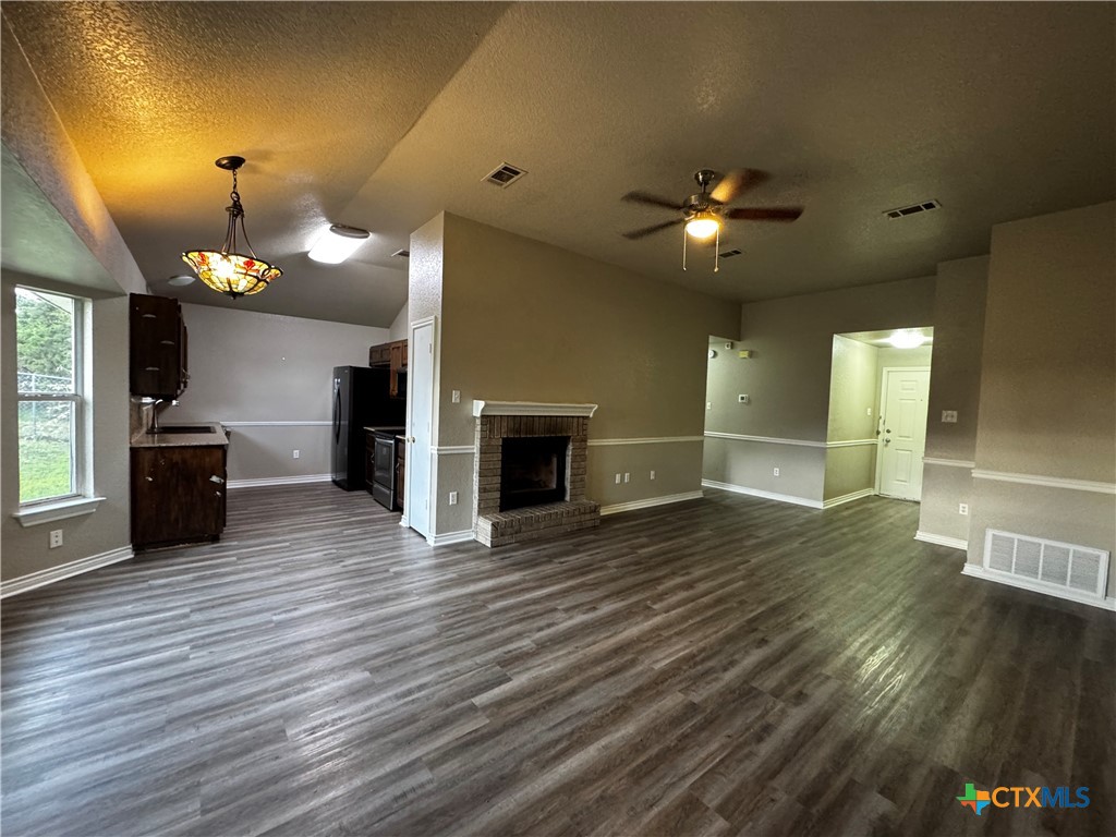 397 County Road 3367 Kempner, TX 76539 - Photo 9 of 47 an empty room with wooden floor fireplace and windows