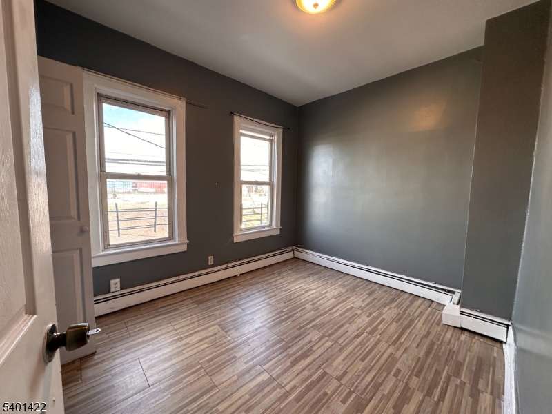 748 Trumbull Street, Unit 2 Elizabeth, NJ 07201 - Photo 3 of 13 an empty room with wooden floor and windows