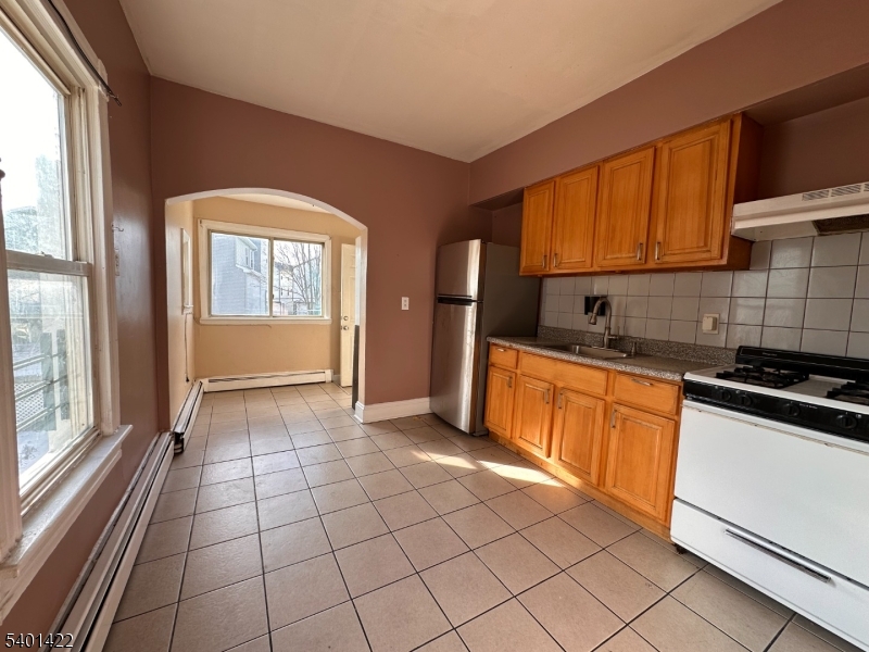 748 Trumbull Street, Unit 2 Elizabeth, NJ 07201 - Photo 6 of 13 a kitchen with stainless steel appliances granite countertop a stove a sink and a microwave