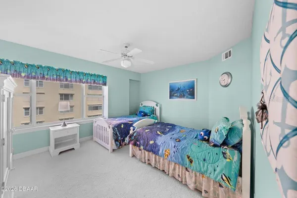 a bedroom with two beds and a large window