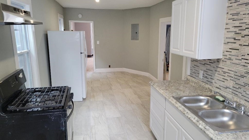 222 Webster Avenue Chelsea, MA 02150 - Photo 9 of 13 a kitchen with granite countertop a sink stove and refrigerator