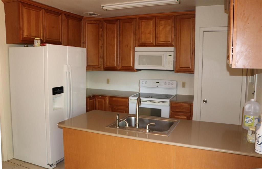 585 Manco Road Lewisville, TX 75067 - Photo 3 of 7 a kitchen with stainless steel appliances a refrigerator sink and cabinets