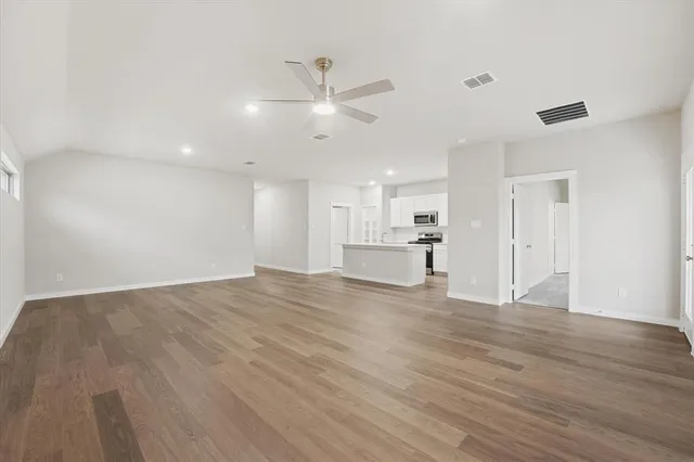 a view of empty room with wooden floor and window