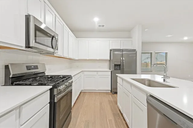a kitchen with a sink stove and refrigerator