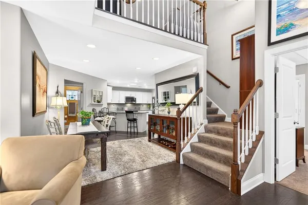 a living room with furniture and a dining table with wooden floor