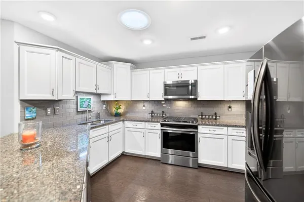 a kitchen with stainless steel appliances granite countertop a sink stove and refrigerator